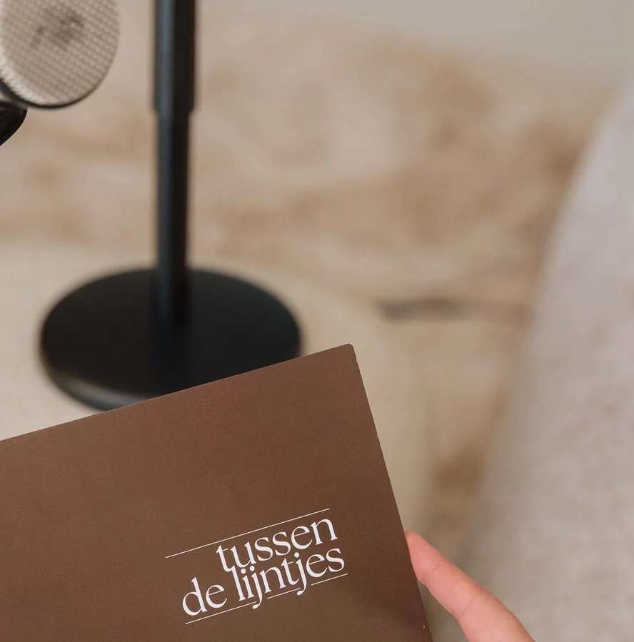 Kaart van de podcast Tussen de lijntjes van Art Medico Clinic bij een microfoon